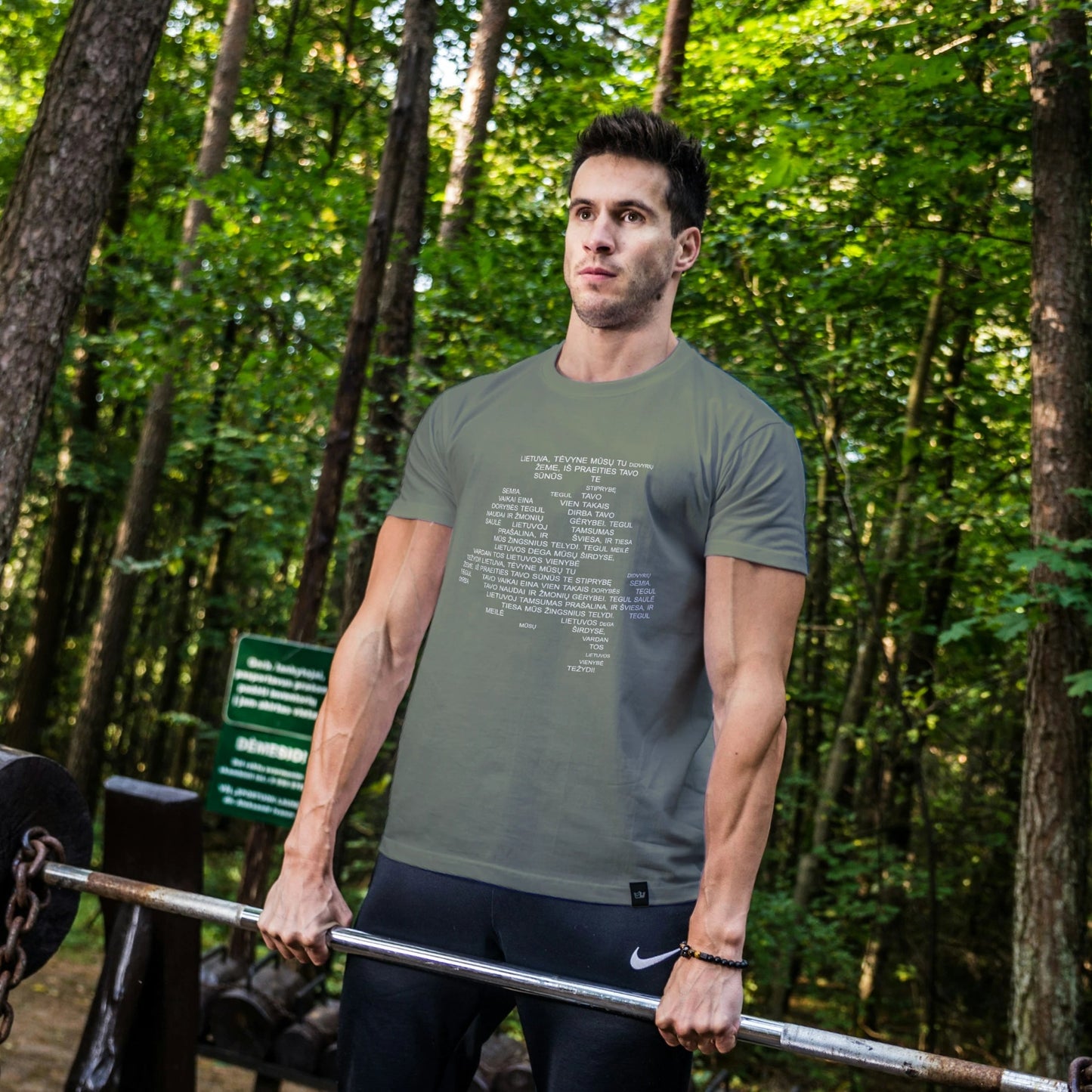 Man lifting weights in a forest setting